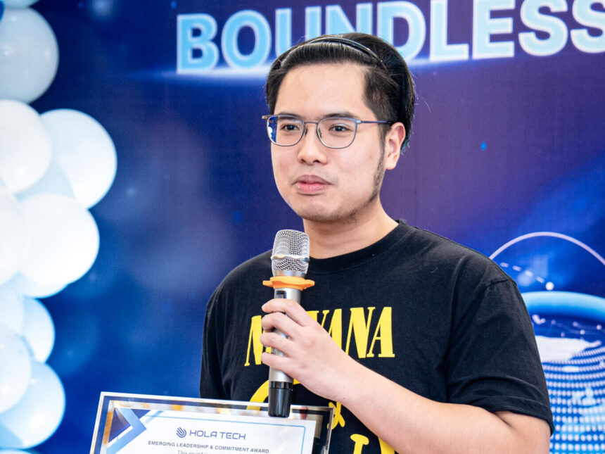 A Hola Tech speaker on stage at a company award event